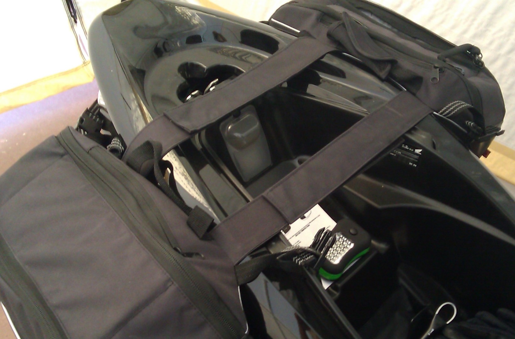 here are the saddlebags attached under the seat. There are two straps that go under the seat at the front and two that go below the taillight at the back. If you remove the wide straps that go under the seat, the two bags will clip together and there is a handle that hooks together with velcro, so you use the bag as a small briefcase (no large laptop will fit -- although tablets and/or winbooks would be fine).