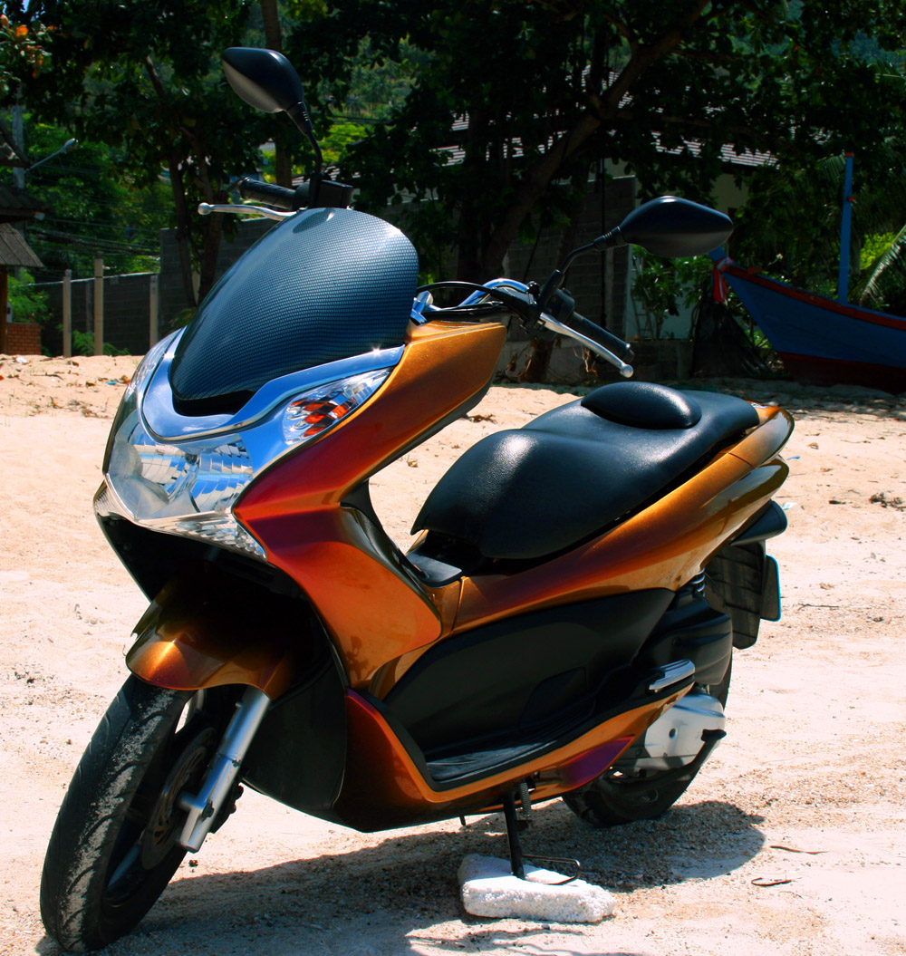 Chameleon paint (red/gold/green) with Carbon fiber windscreen on a 2012 Honda PCX 125, On the beach in front of my shop :)